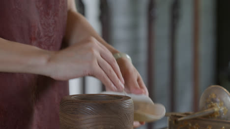 Placing-tea-leaves-on-a-grinder-preparing-the-traditional-Chinese-tea-ceremony