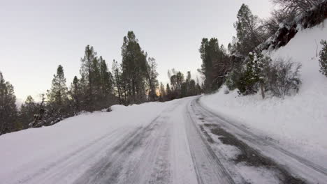 driving down a snowy road path trail in the mountains first person pov