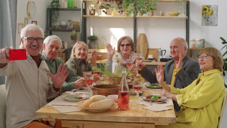 Senior-Friends-Taking-Selfie-at-Home-Dinner-Party