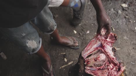 african man snatching meat with hands