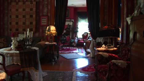 abundan las antigüedades y los muebles victorianos dentro de una sala de estar y un salón ricamente decorados