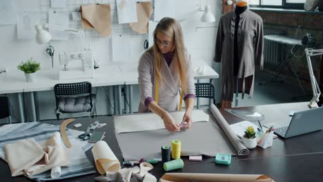 slow motion portrait of professional seamstress creating new fashionable garment in studio