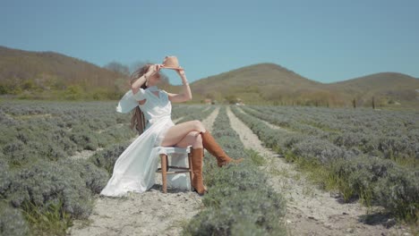 mujer con un vestido blanco sentada en un campo de lavanda