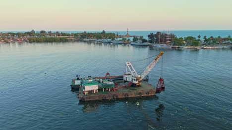 excavadora flotante en plataforma limpiando el sucio río ozama en la república dominicana
