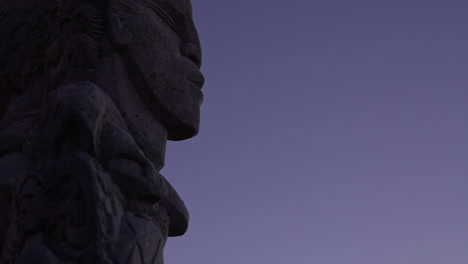 Close-up-at-night-time-of-a-Maori-stone-carving-statue-in-Wellington,-New-Zealand
