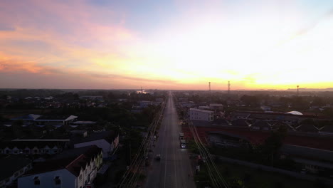 Paso-Elevado-Aéreo-De-La-Carretera-Principal-En-La-Ciudad-De-Surat-Thani-Durante-La-Puesta-De-Sol-Dorada,-Tailandia---Estableciendo-Un-Disparo-Con-Drones