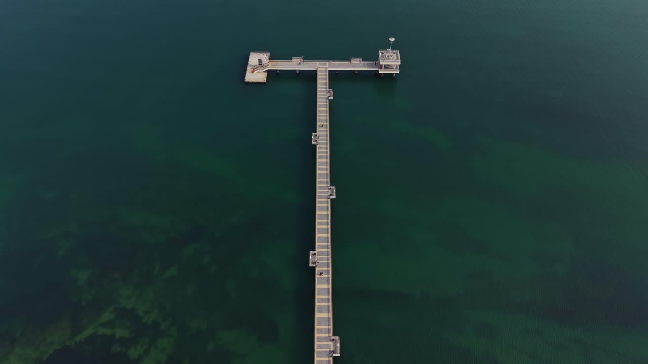 Vista dall'alto con drone di un lungo molo e spiaggia