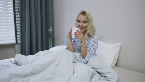 lovely woman drinking in bed