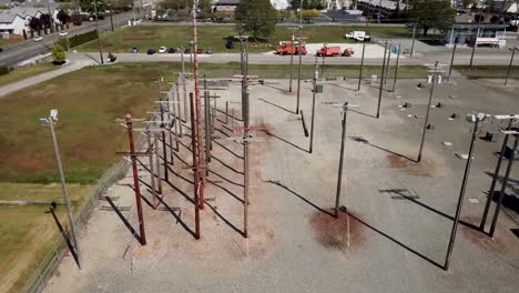 postes telefónicos situados en los campos de entrenamiento vacíos de la universidad técnica bates en un día soleado en tacoma, estado de washington, ee.uu. - tiro lateral aéreo