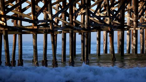 ocean waves hitting the legs of the crystal beach pier