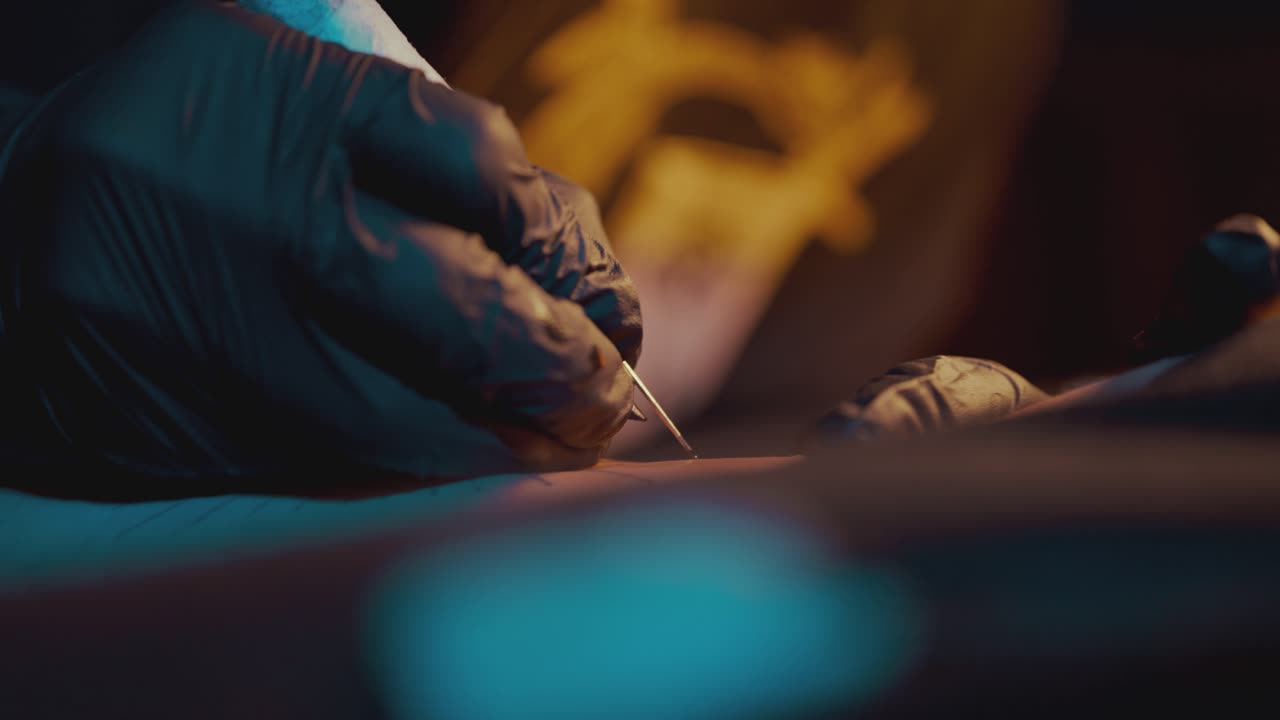 Tattoo Artist Putting Tattoo On The Arm Using The Handpoke Method - close up