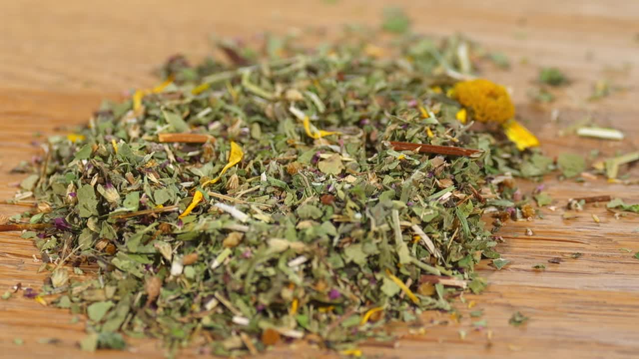 Primo piano macro di una miscela di tisane essiccate con fiori e foglie su un tavolo di legno. Ingredienti naturali biologici per una bevanda salutare, perfetti per temi di benessere, medicina erboristica e cibo