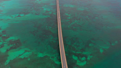 Aerial-view-of-cars-passing-the-Irabu-Bridge,-Miyakojima,-Okinawa,-Japan