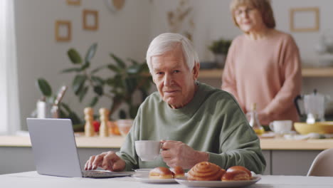 Porträt-Eines-älteren-Mannes-Mit-Laptop-Und-Teetasse-Zu-Hause