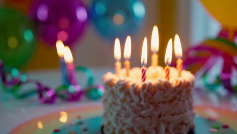 birthday cake with lit candles and party decorations