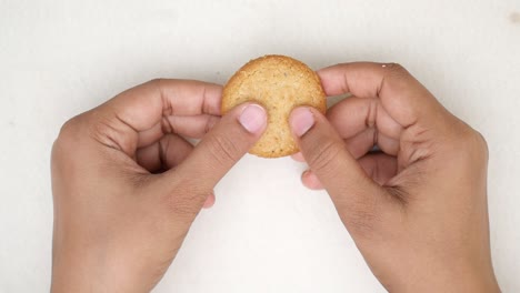 breaking an oatmeal cookie in half