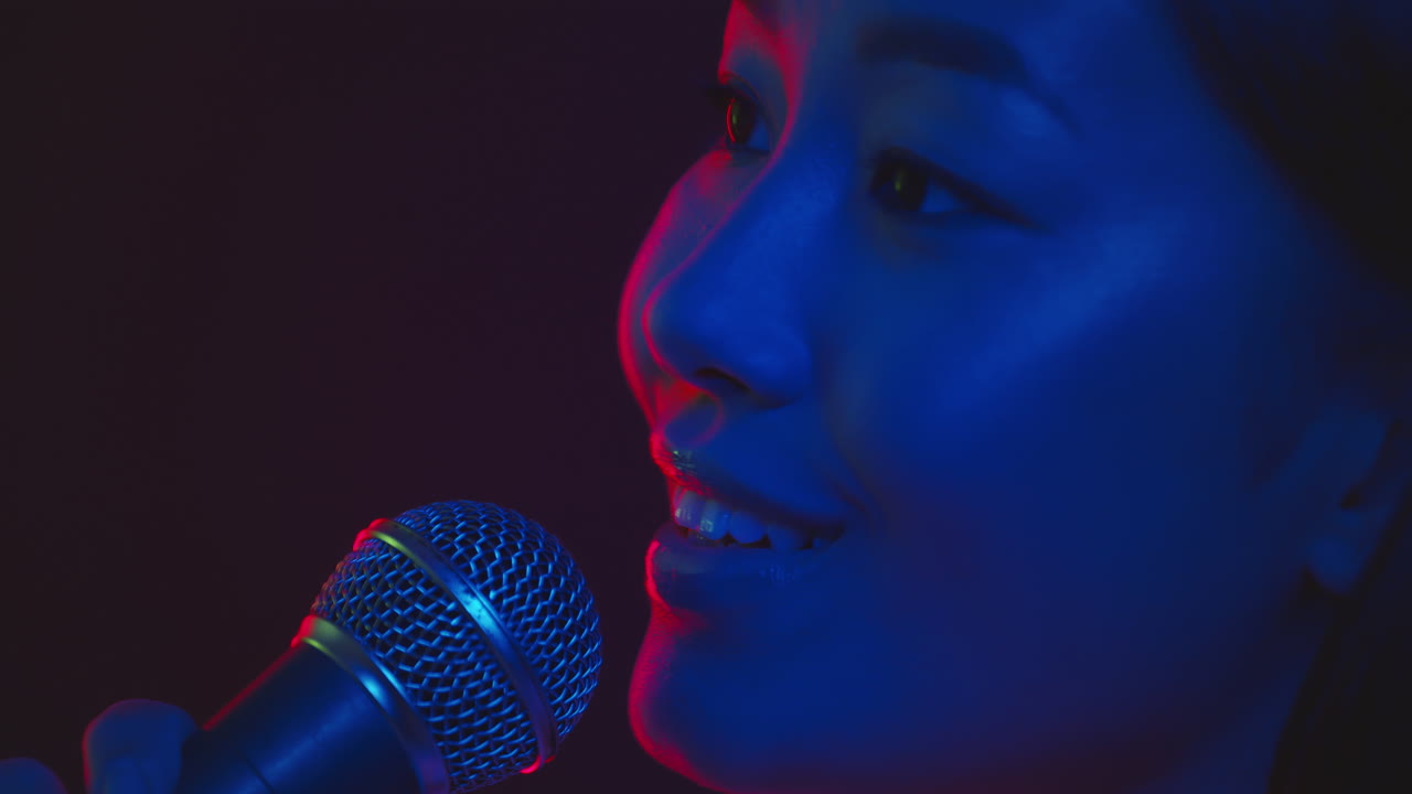 Woman Singing Into Microphone in Neon Light
