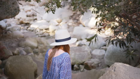 woman hiking through a mountain stream