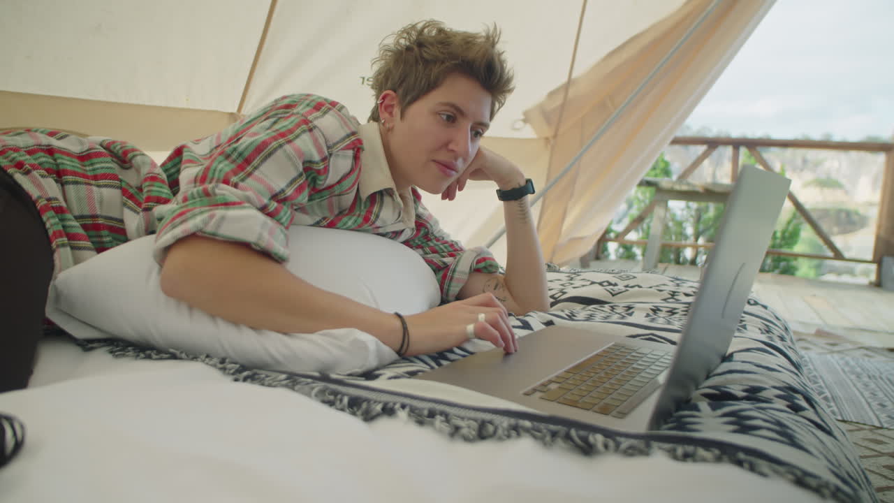 Woman Resting in Glamping Tent and Watching Movie on Laptop