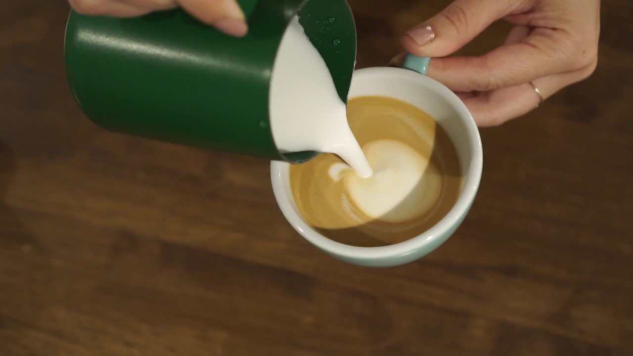SLOWMO - Professional female barista makes tulip in cappuccino - close up