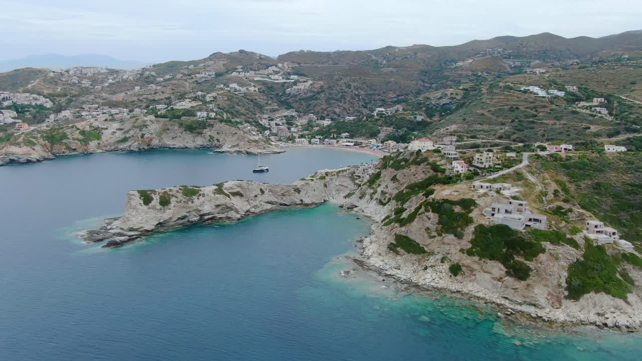 Wide angle dolly in drone aerial shot of beautiful beaches, houses, hills, and mountains in Creta Islands, Greece during the day