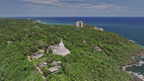 Unawatuna-Sri-Lanka-Aerial-v9-cinematic-drone-flyover-lush-green-jungle-capturing-hillside-Japanese-Peace-Pagoda-Rumassala-Temple-and-coastal-ocean-view-in-summer---Shot-with-Mavic-3-Cine---April-2023