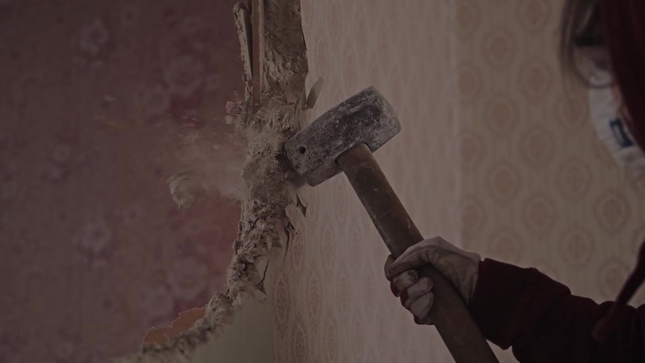 Sledgehammer Breaking Wall During Apartment Demolition Project