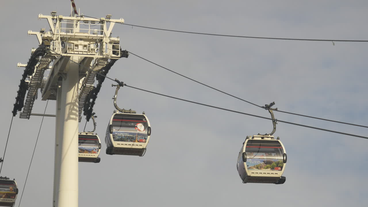 Cable cars travel along cable line passing a support tower structure public transportation
