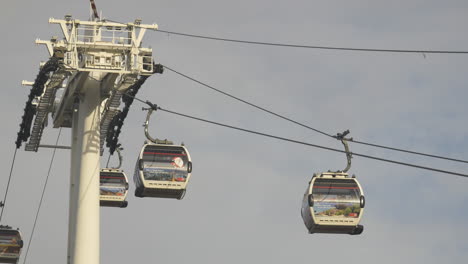 cable cars travel along cable line passing a support tower structure public transportation
