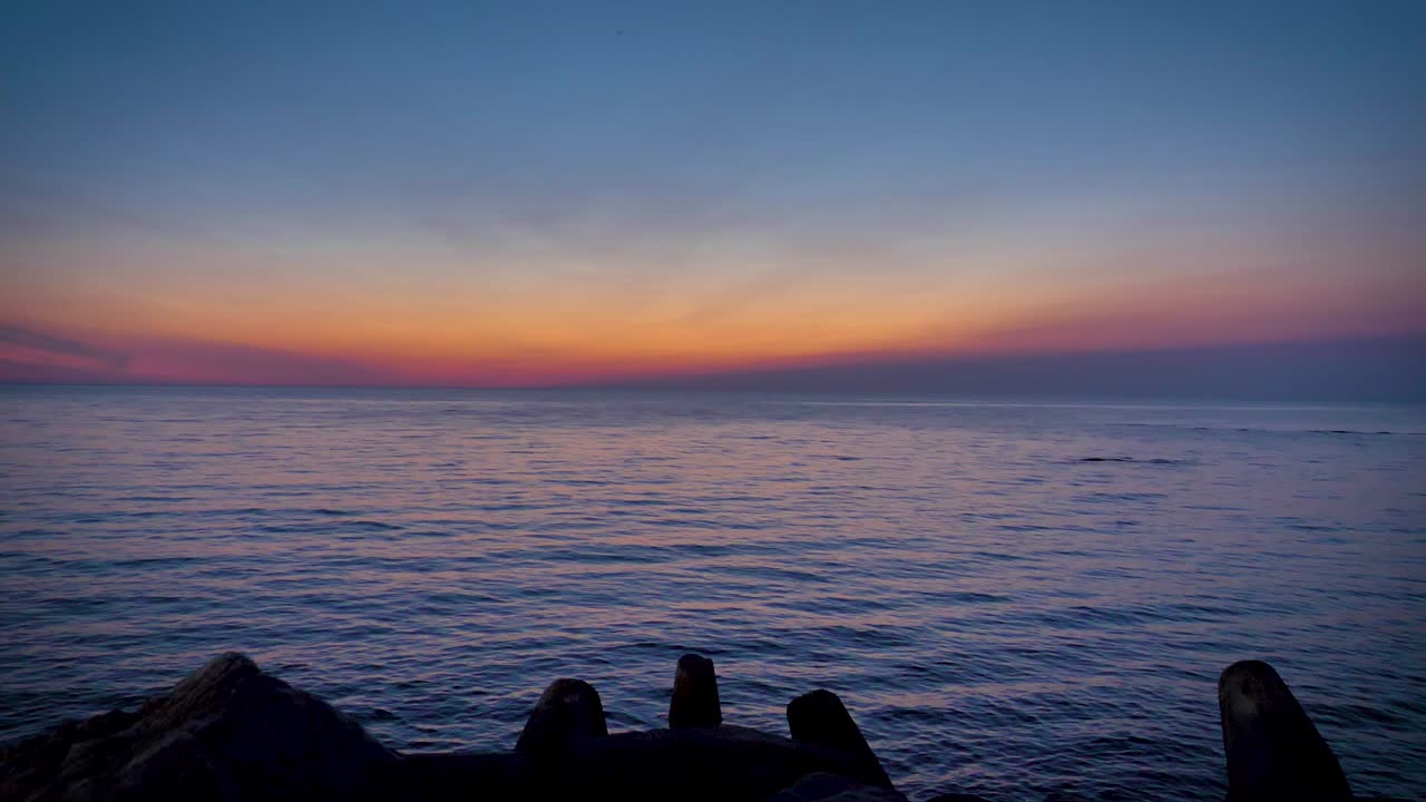静かな水の美しい低角度の景色 マグダレン諸島のカラフルな日没の光を反映しています