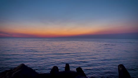 beautiful low angle view of calm water reflecting the light of a colorful sunset in the magdalen islands