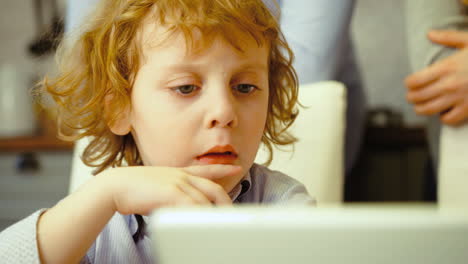 blue eyed kid watching somehting on his tablet