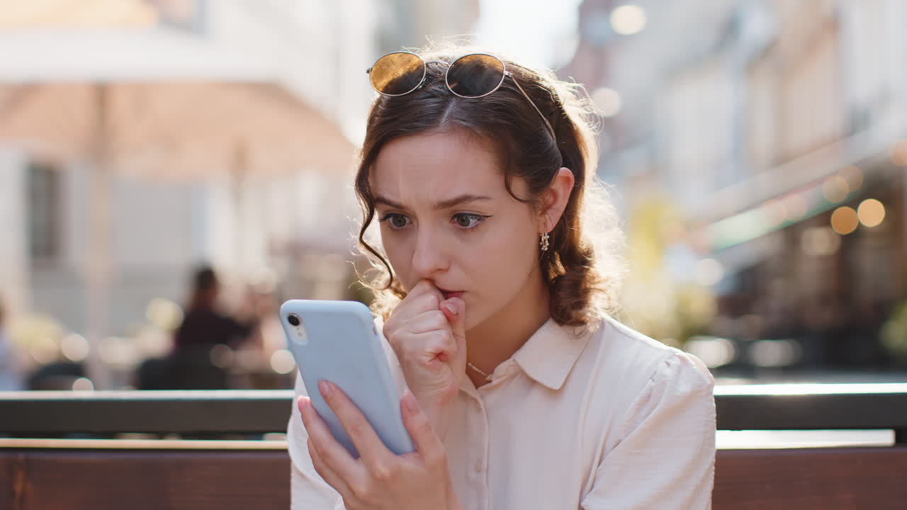 Surprised young woman use smartphone loses bad news fortune loss fail outdoors in city street