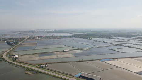 4K-Aerial-Drone-Footage-of-the-Salt-Lakes-in-Phetchaburi-with-a-Road-Bending-in-Thailand