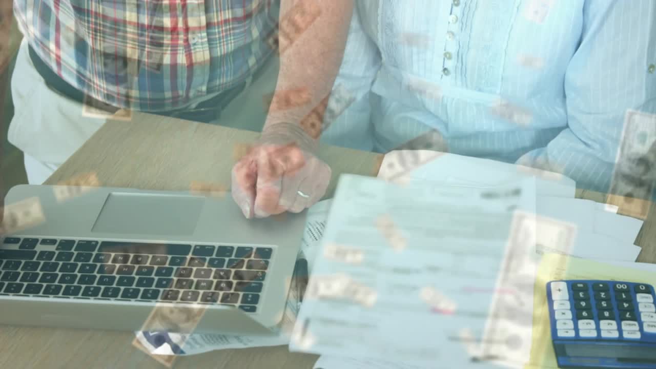 Un uomo anziano posa la mano sul trackpad del laptop mentre una donna esamina le finanze con banconote da un dollaro fluttuanti.