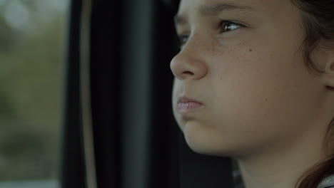 Young-teenage-girl-riding-in-a-car-with-a-thoughtful-expression