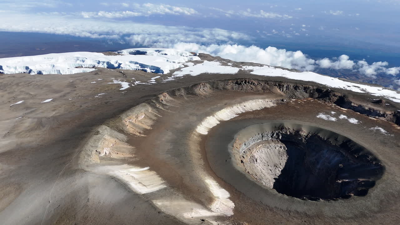 키리만자로 산의 우루루 피크와 그 아래의 화산 분화구의 드론.