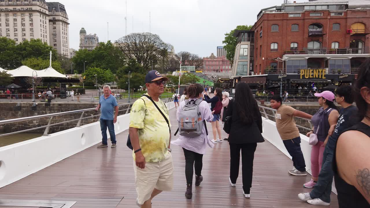 POV Walk through Women's Bridge at Puerto Madero, tourists at Buenos Aires city travel spot