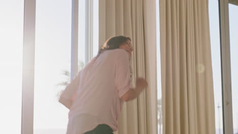 mujer feliz bailando en la habitación del hotel divirtiéndose disfrutando de un viaje exitoso vacaciones saludables mujer de mediana edad celebrando la jubilación al amanecer