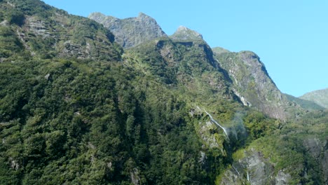 a mesmerizing waterfall cascades seemingly into nowhere, embraced by towering mountains above, creating a surreal and captivating scene