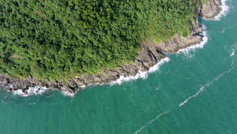 aerial view of a jagged rock island, surrounded with lush green nature and hong kong bay water