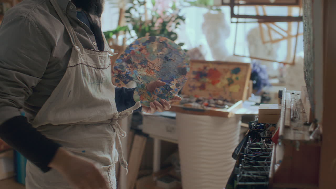 Painter Setting Canvas on Easel and Taking Palette in Studio