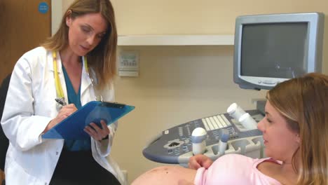 Doctor-taking-down-notes-from-a-pregnant-patient