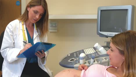 doctor taking down notes from a pregnant patient