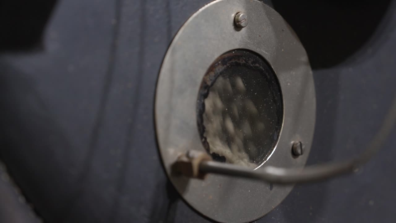 Green coffee beans rotating behind the roaster inspection window