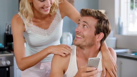 una pareja atractiva mirando su teléfono inteligente.