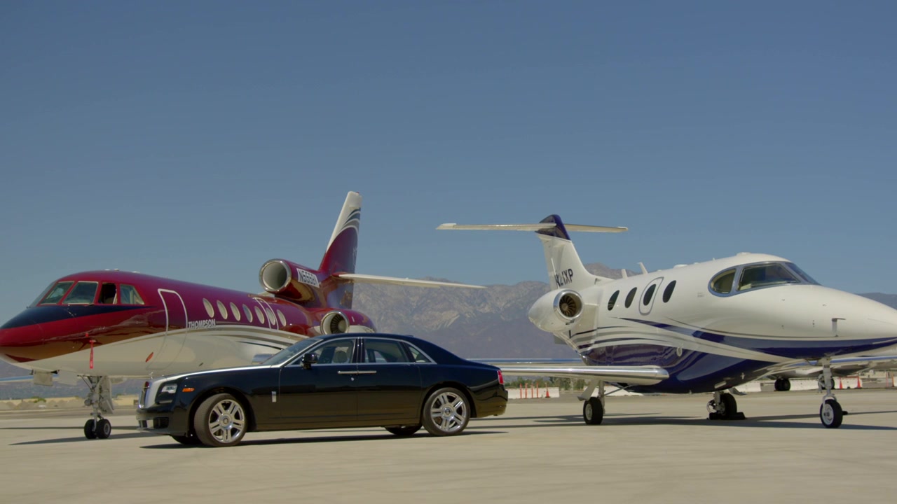 Auto Rolls Royce nera all'aeroporto con aerei privati