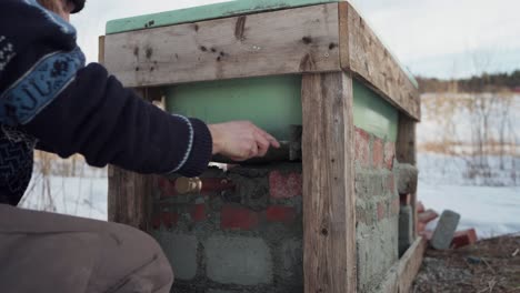 el hombre está aplicando cemento y llenando el área con rocas debajo de la bañera de agua caliente diy - timelapse