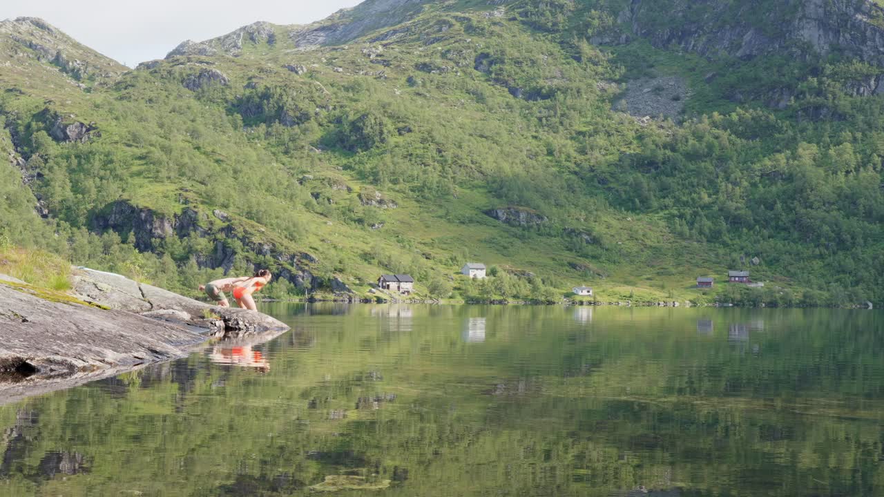 30대 부부는 서노르웨이 바크스달에 있는 얼어붙은 산 호수에 뛰어들어 은 날 수영을 하고 있다.