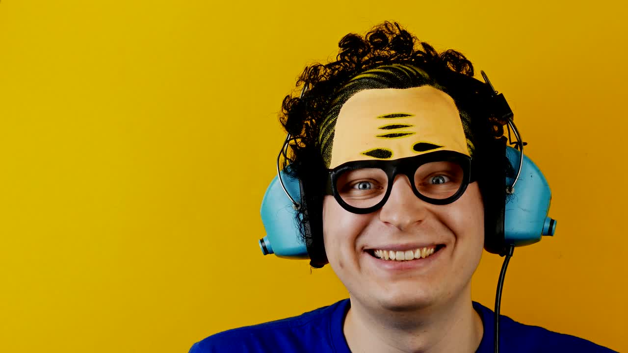 hombre rizado loco con auriculares retro o auriculares se ríe nerviosamente